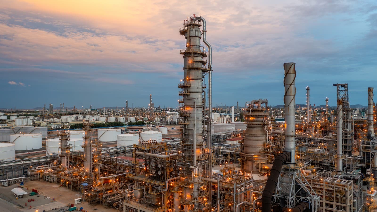 Vista aérea de refinaria e complexo industrial de petróleo com tanques e torres