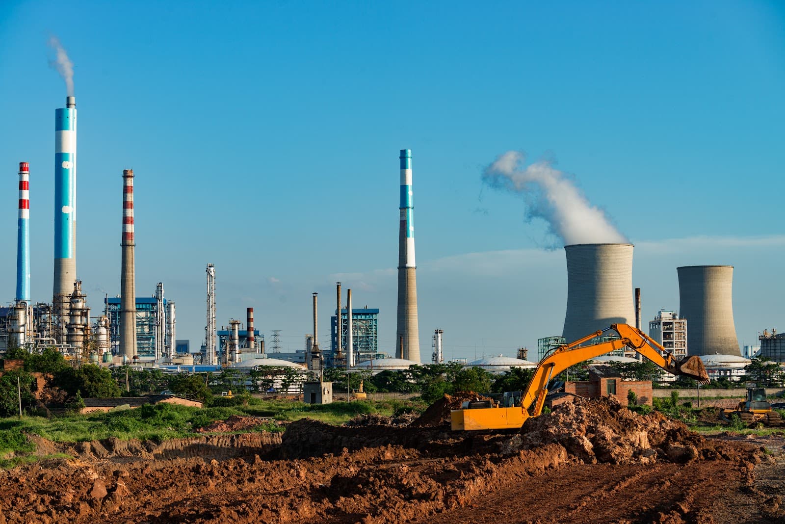 Escavação industrial sob céu azul durante o dia com máquinas em canteiro de obras.