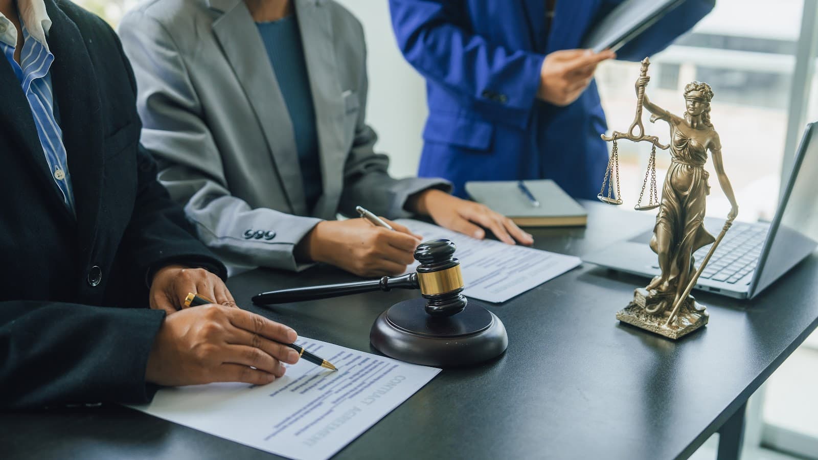 Reunião de negócios com profissionais discutindo documentos legais sobre a mesa.