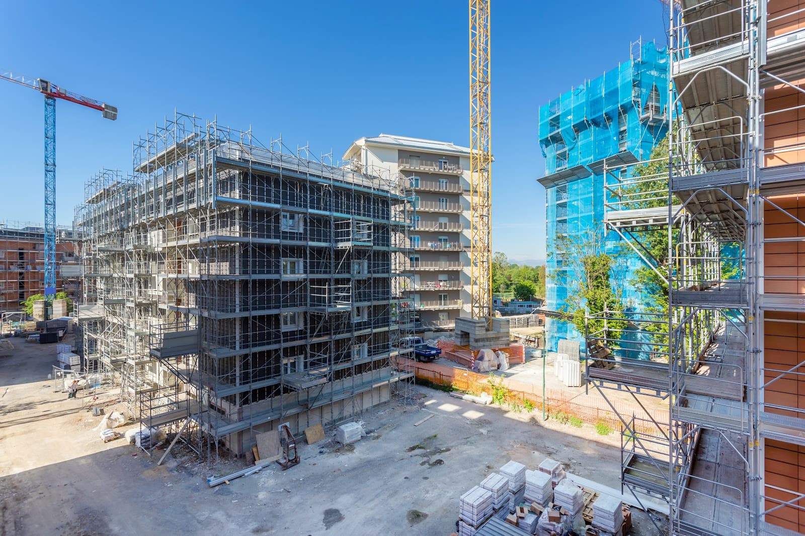 Gruas de construção e edifícios sob céu limpo.