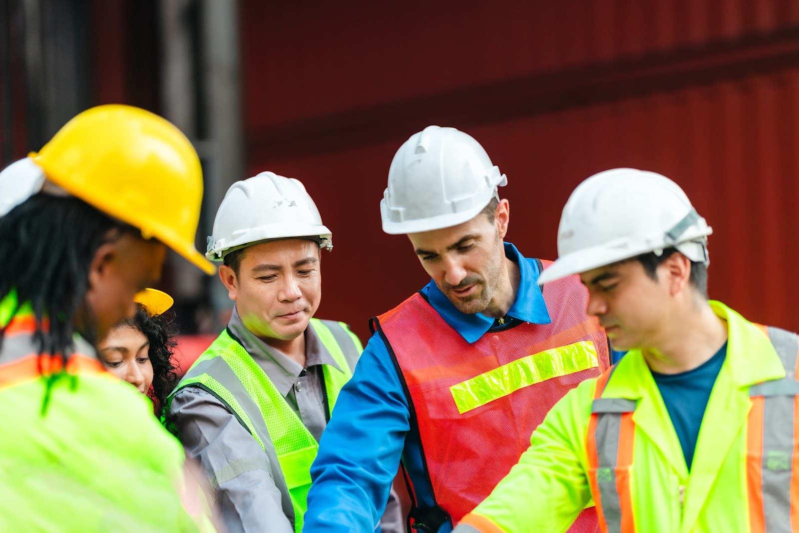 Engenheiros revisam plantas e documentos técnicos em canteiro de obras industrial.