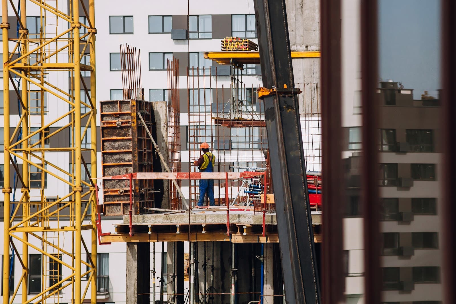 Engenheiros e trabalhadores usando capacetes em canteiro de obras.