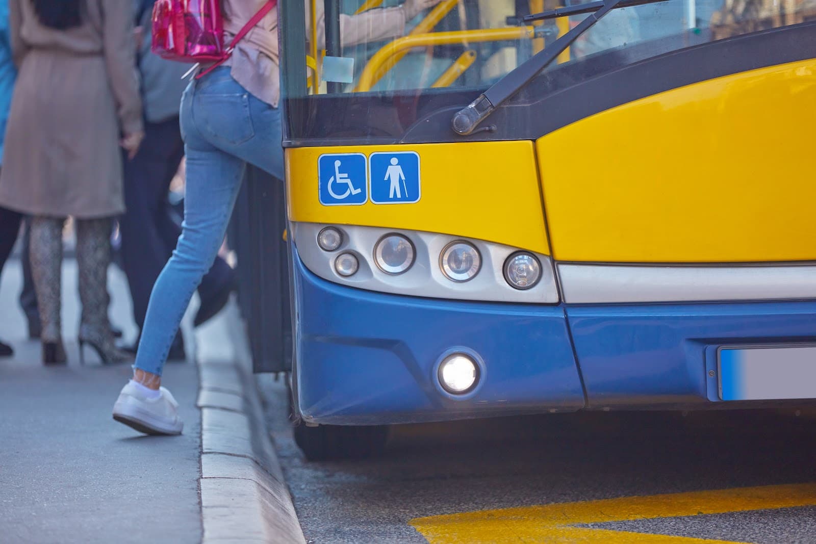 Onibus de transporte publico circulando em canteiro urbano com edificios ao fundo.