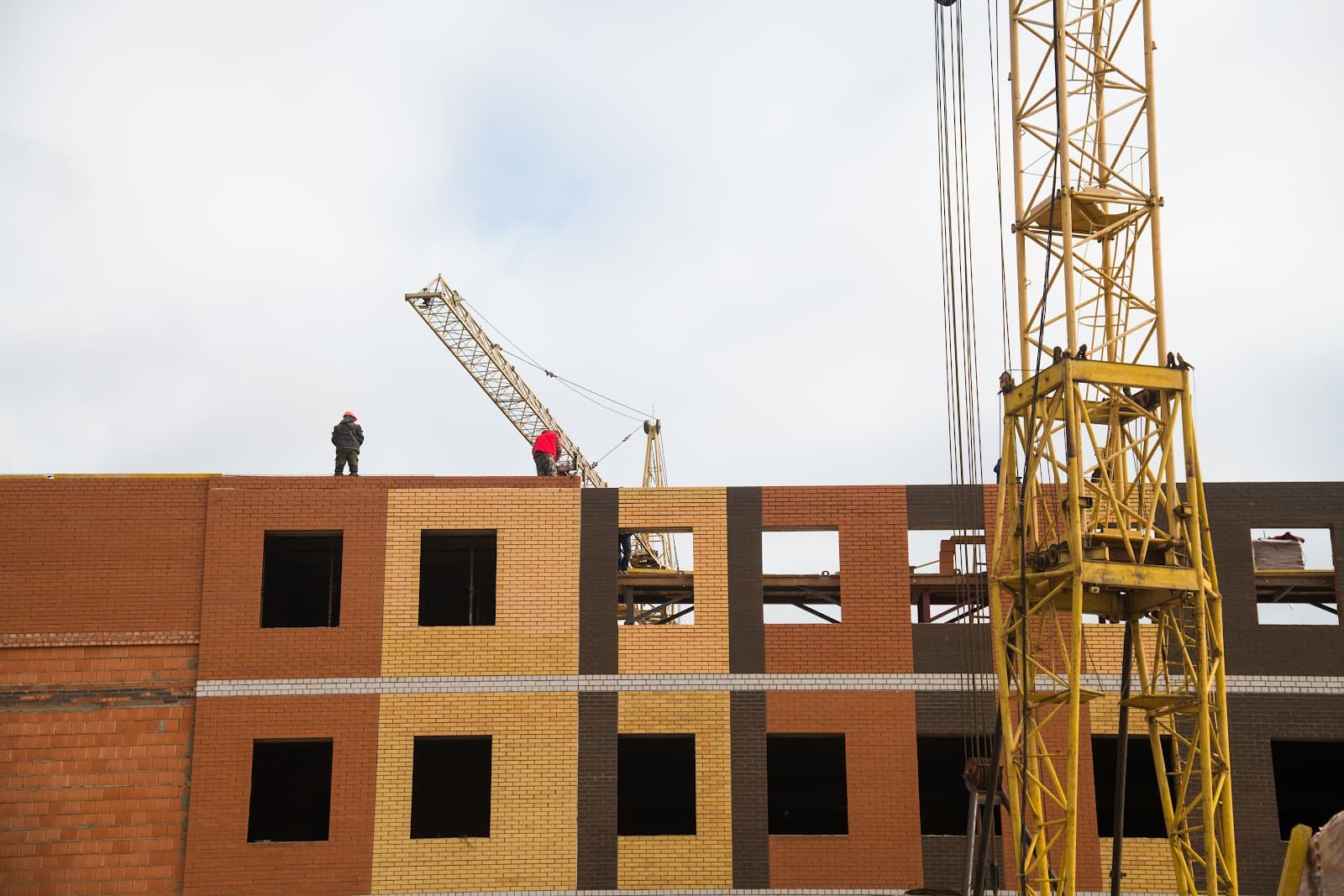 Construcao de edificio com estrutura de andares e canteiro de obras em andamento sob o ceu.