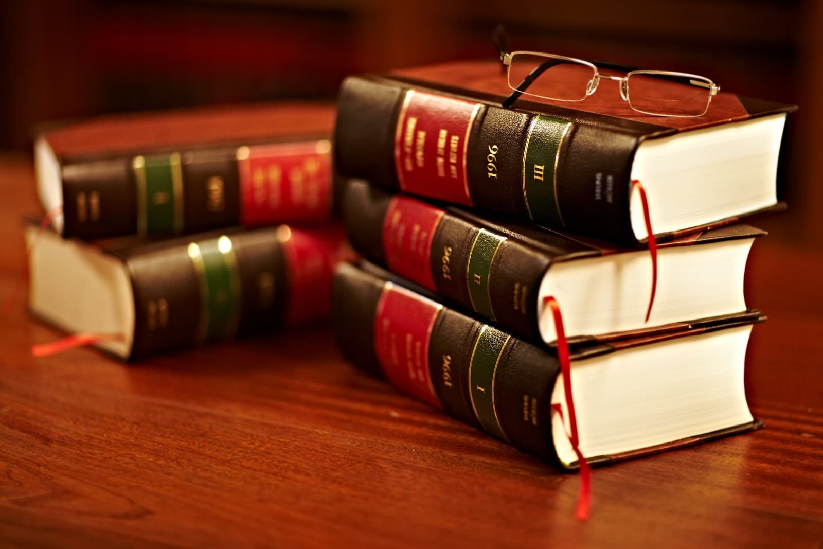 Livros de leis e oculos sobre mesa de madeira