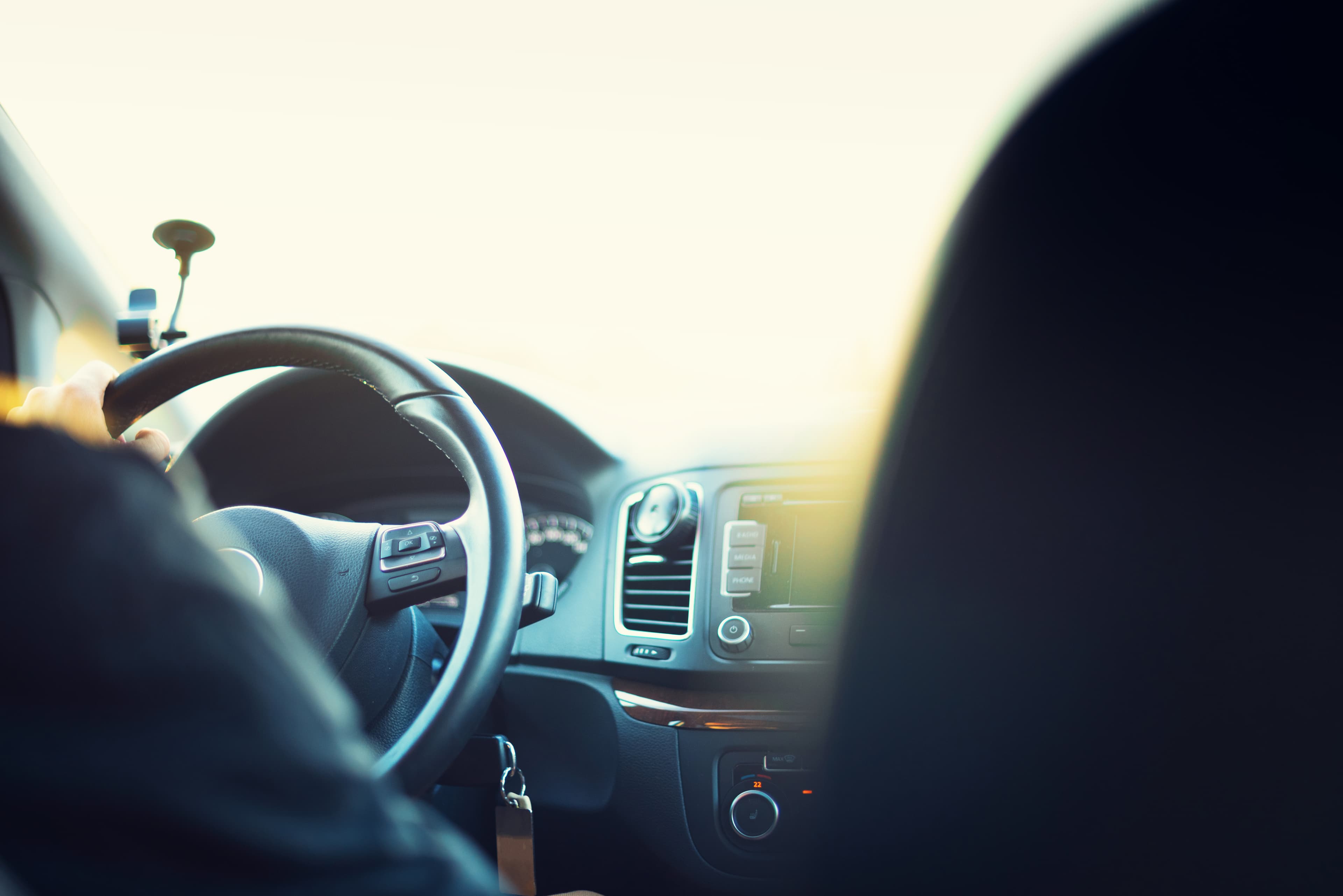 Imagem ilustrativa do interior de um automóvel, com motorista ao volante.