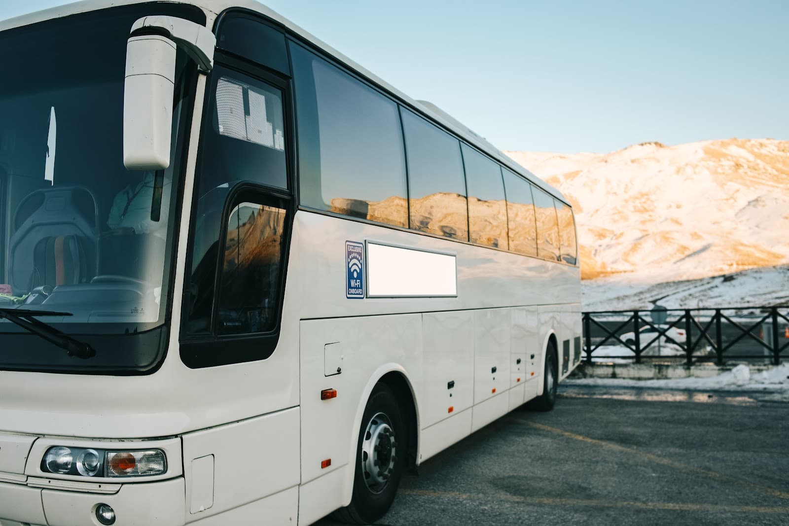 Onibus de turismo estacionado proximo a cadeia de montanhas