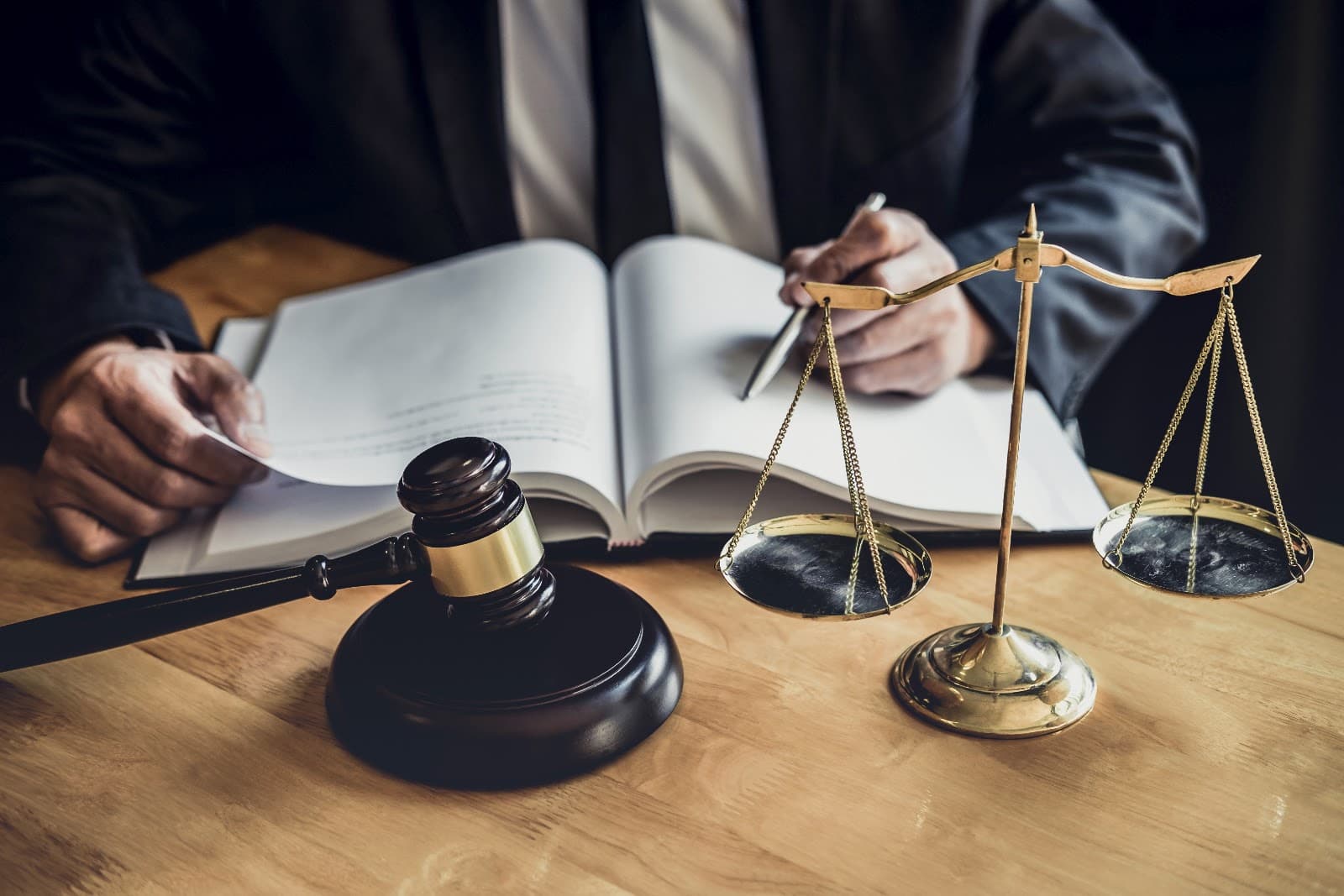 Martelo de juiz e balança da justiça sobre mesa de madeira em escritório