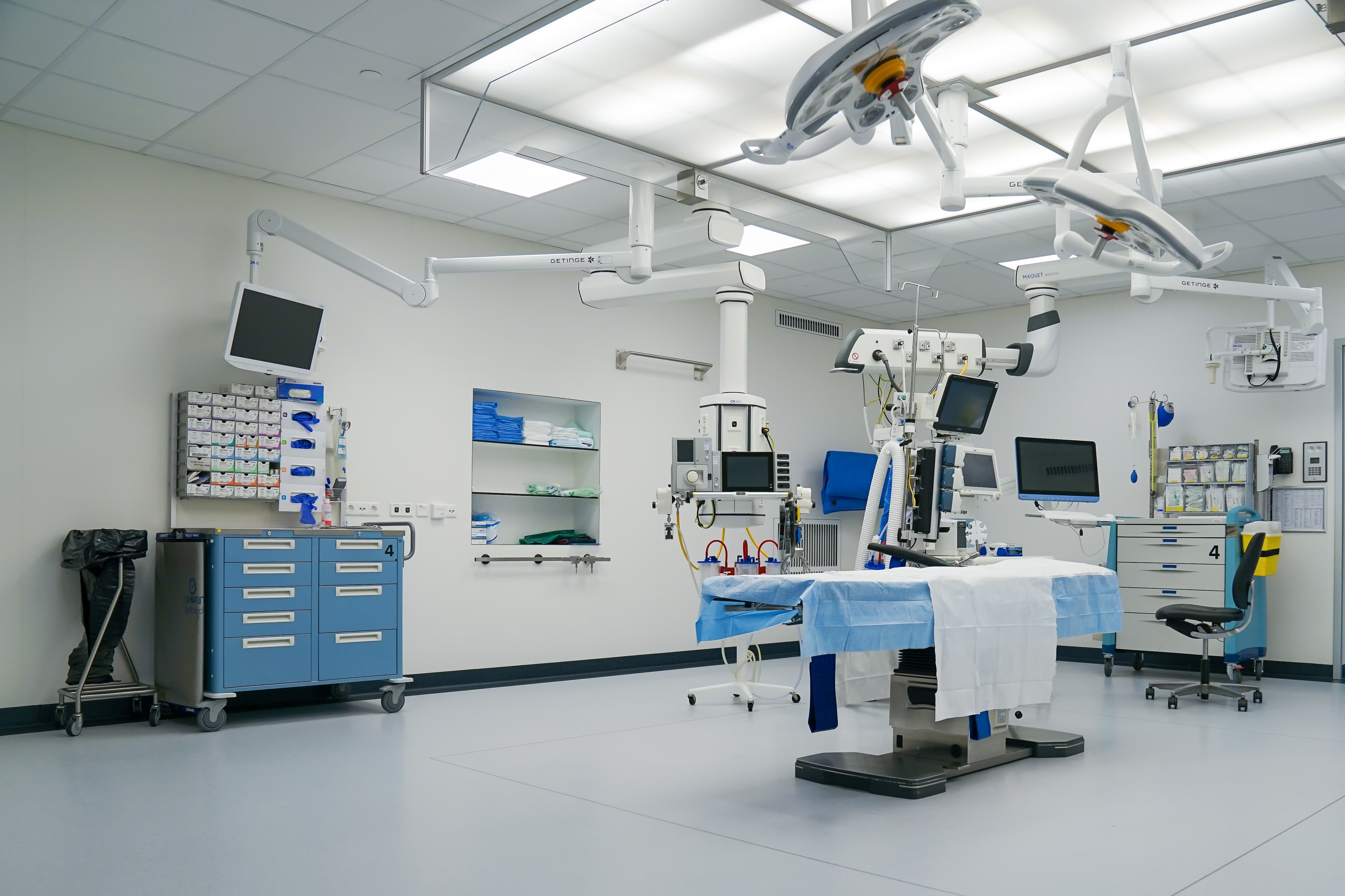 Imagem ilustrativa: sala cirúrgica vazia com mesa, monitores e equipamentos hospitalares, sem relação documental com a rede contratada por Palhoça.